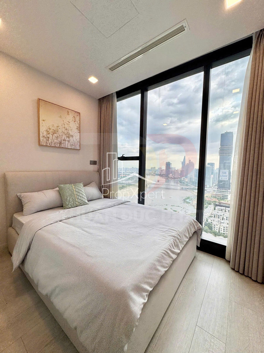 Phòng ngủ chung cư hiện đại với giường đôi bọc nệm màu sáng cạnh cửa kính lớn view thành phố